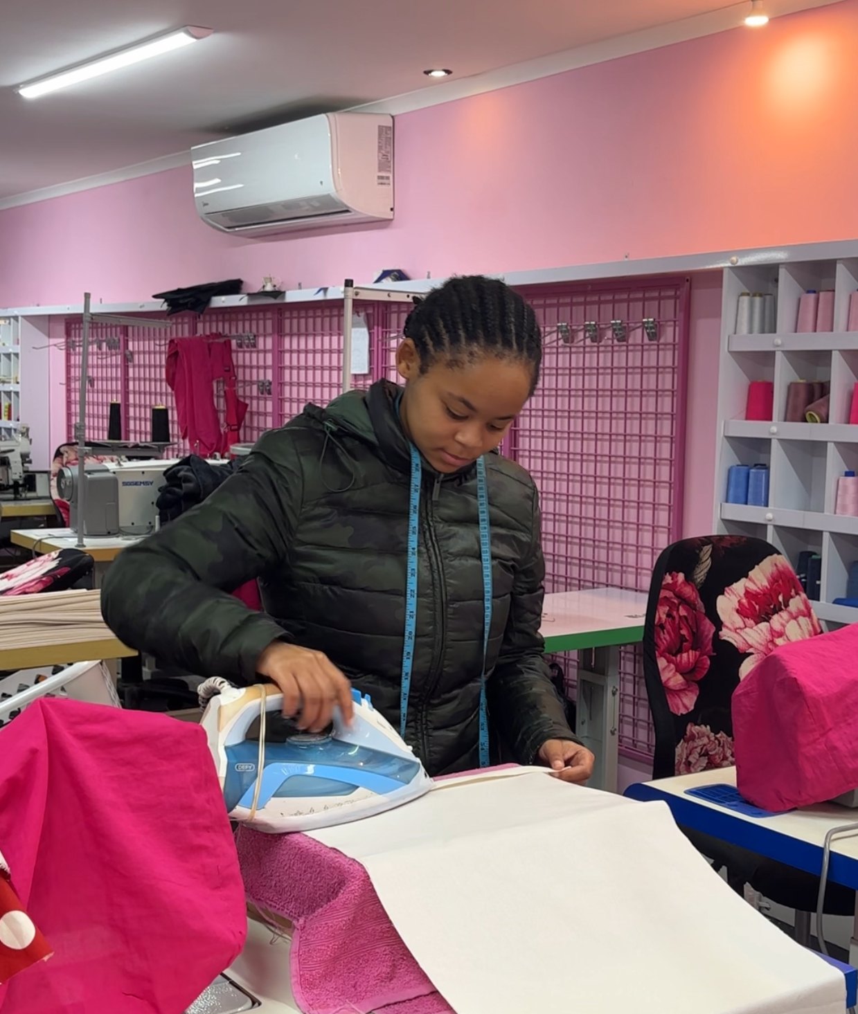 Jodene from Wild Mongoo ironing fabric at the workbench in the pink George workshop